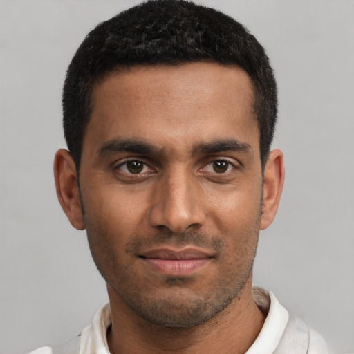 Joyful black young-adult male with short  black hair and brown eyes