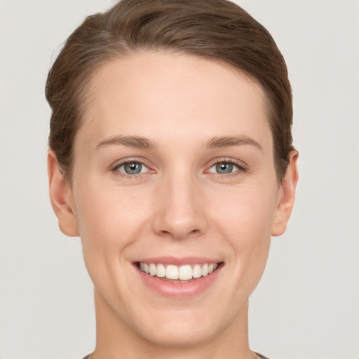 Joyful white young-adult female with short  brown hair and grey eyes