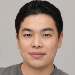 Joyful asian young-adult male with short  black hair and brown eyes