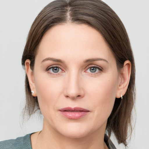 Joyful white young-adult female with medium  brown hair and grey eyes