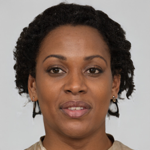 Joyful black adult female with short  brown hair and brown eyes