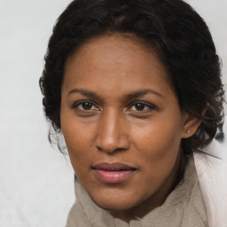 Joyful black adult female with long  brown hair and brown eyes