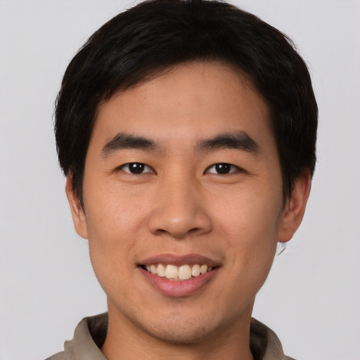 Joyful asian young-adult male with short  brown hair and brown eyes