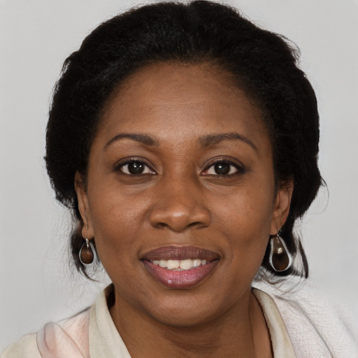 Joyful black adult female with medium  brown hair and brown eyes
