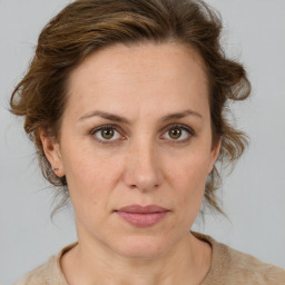 Joyful white adult female with medium  brown hair and green eyes