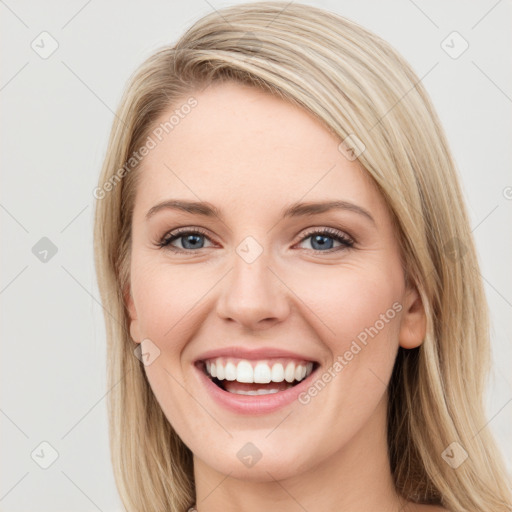 Joyful white young-adult female with long  brown hair and blue eyes