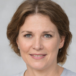 Joyful white adult female with medium  brown hair and grey eyes