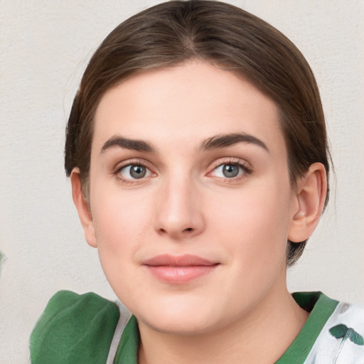 Joyful white young-adult female with medium  brown hair and green eyes