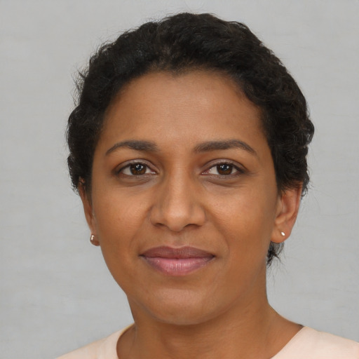 Joyful black young-adult female with short  brown hair and brown eyes
