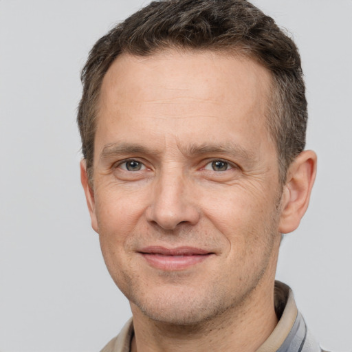 Joyful white adult male with short  brown hair and brown eyes