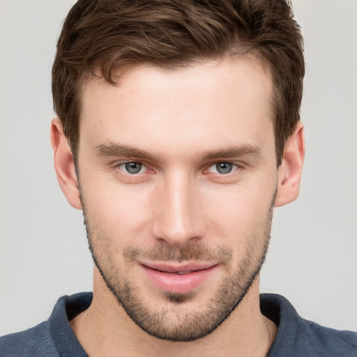 Joyful white young-adult male with short  brown hair and grey eyes