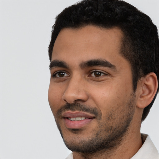 Joyful latino young-adult male with short  black hair and brown eyes