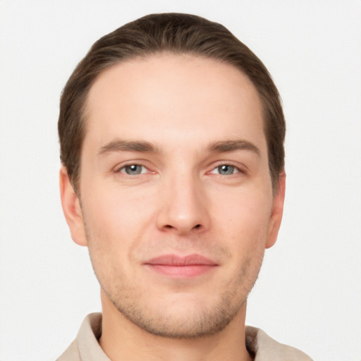 Joyful white young-adult male with short  brown hair and grey eyes