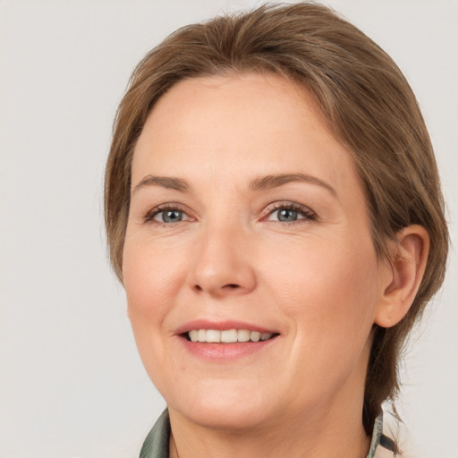 Joyful white adult female with medium  brown hair and grey eyes