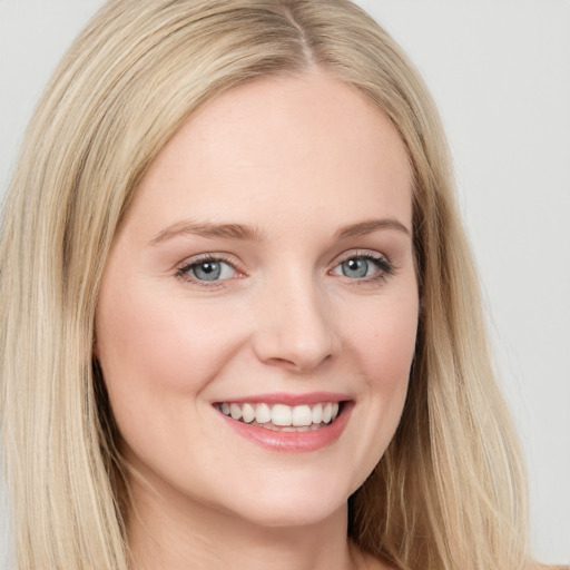 Joyful white young-adult female with long  brown hair and blue eyes