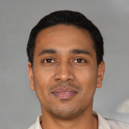 Joyful latino young-adult male with short  black hair and brown eyes
