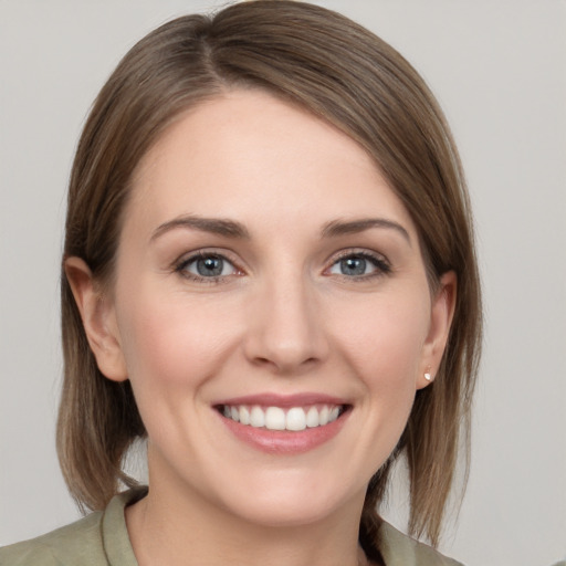 Joyful white young-adult female with medium  brown hair and grey eyes