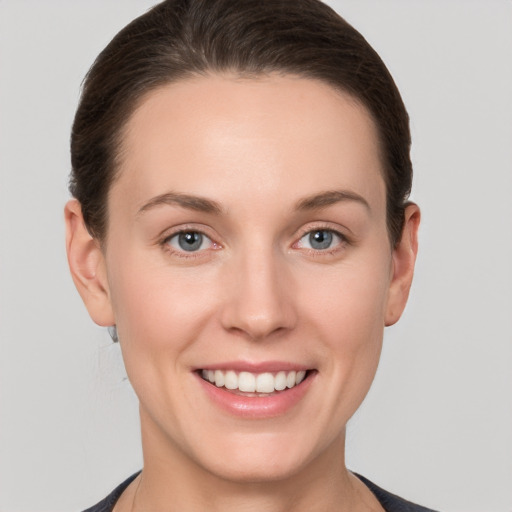 Joyful white young-adult female with short  brown hair and grey eyes