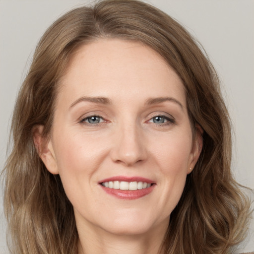 Joyful white adult female with medium  brown hair and grey eyes