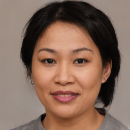 Joyful asian adult female with medium  brown hair and brown eyes