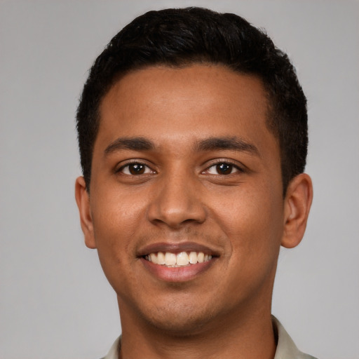 Joyful black young-adult male with short  brown hair and brown eyes