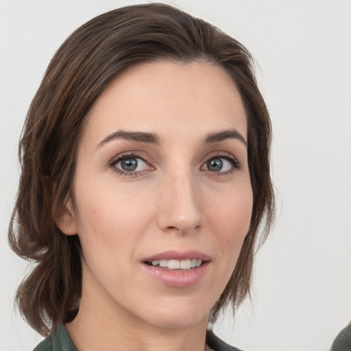 Joyful white young-adult female with medium  brown hair and grey eyes