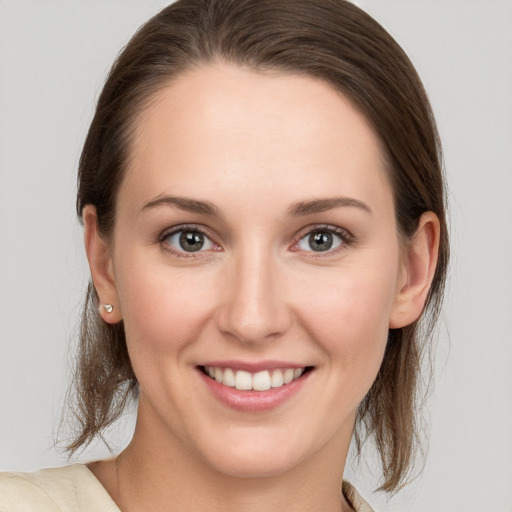 Joyful white young-adult female with medium  brown hair and grey eyes