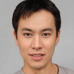 Joyful asian young-adult male with short  brown hair and brown eyes