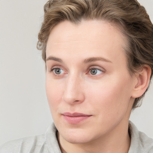 Joyful white young-adult female with short  brown hair and blue eyes