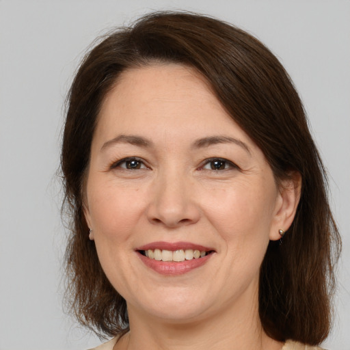 Joyful white adult female with medium  brown hair and brown eyes