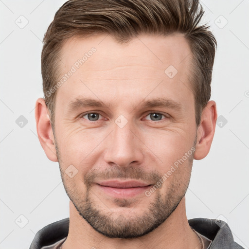 Joyful white young-adult male with short  brown hair and grey eyes