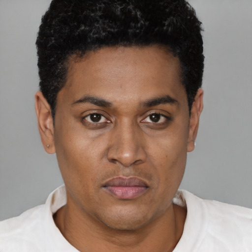 Joyful black young-adult male with short  brown hair and brown eyes