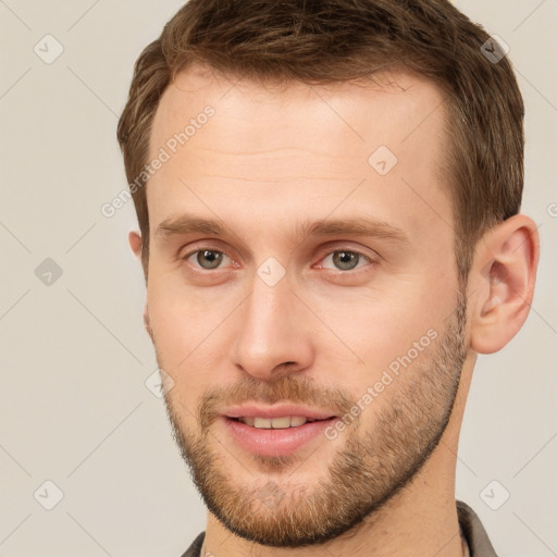 Joyful white young-adult male with short  brown hair and grey eyes