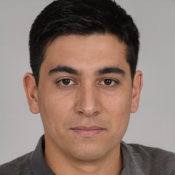 Joyful white young-adult male with short  black hair and brown eyes