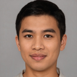 Joyful asian young-adult male with short  brown hair and brown eyes