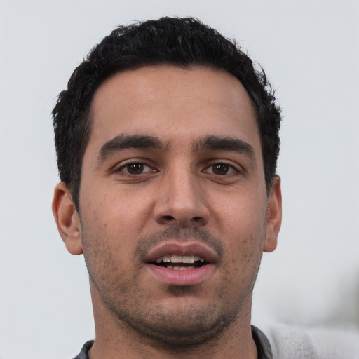 Joyful white young-adult male with short  black hair and brown eyes