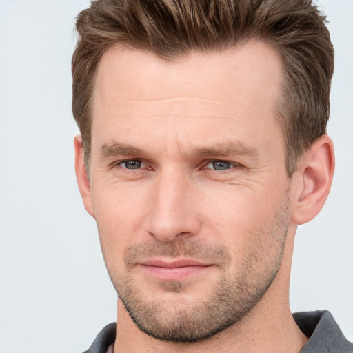 Joyful white adult male with short  brown hair and grey eyes