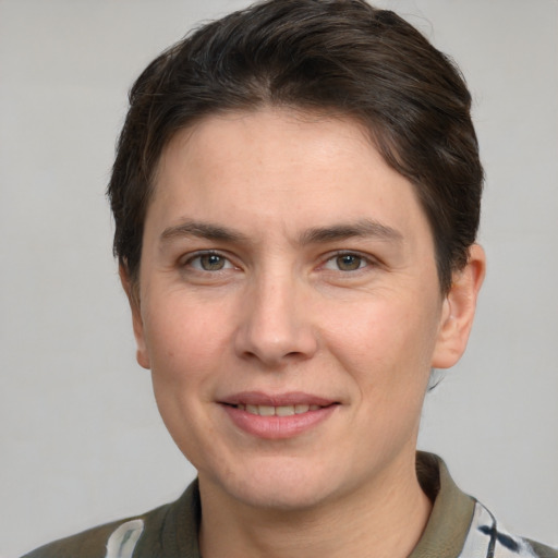 Joyful white young-adult female with short  brown hair and grey eyes