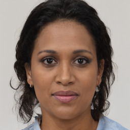 Joyful black adult female with medium  brown hair and brown eyes