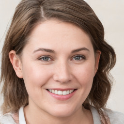 Joyful white young-adult female with medium  brown hair and grey eyes