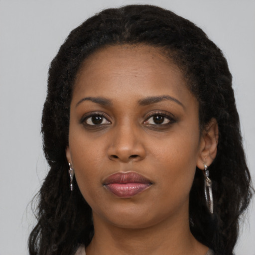Joyful black young-adult female with long  black hair and brown eyes
