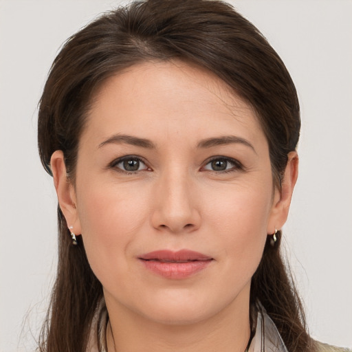 Joyful white young-adult female with long  brown hair and brown eyes