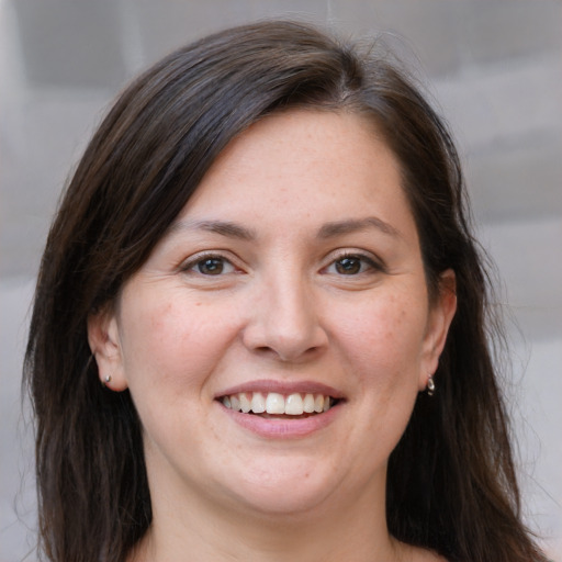 Joyful white adult female with medium  brown hair and grey eyes