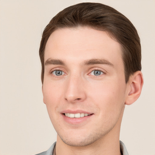 Joyful white young-adult male with short  brown hair and grey eyes