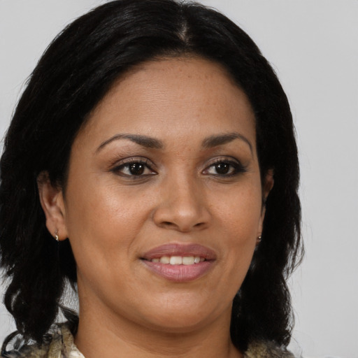 Joyful latino adult female with medium  brown hair and brown eyes