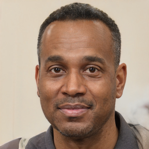 Joyful black adult male with short  black hair and brown eyes