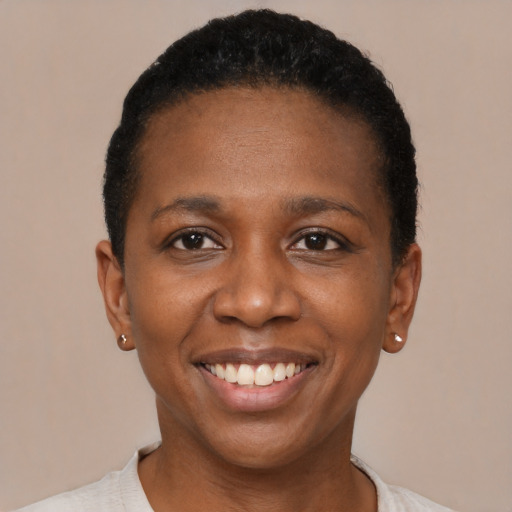 Joyful black young-adult female with short  black hair and brown eyes