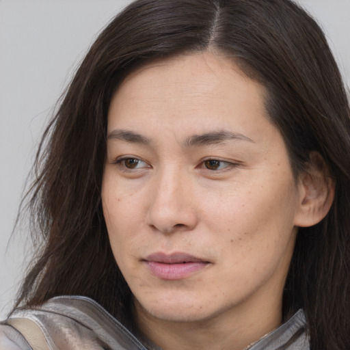 Joyful asian young-adult female with long  brown hair and brown eyes