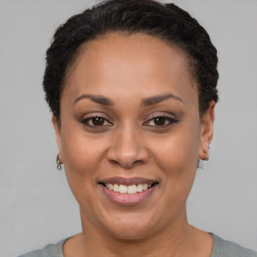 Joyful latino adult female with short  black hair and brown eyes