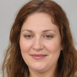 Joyful white adult female with long  brown hair and brown eyes